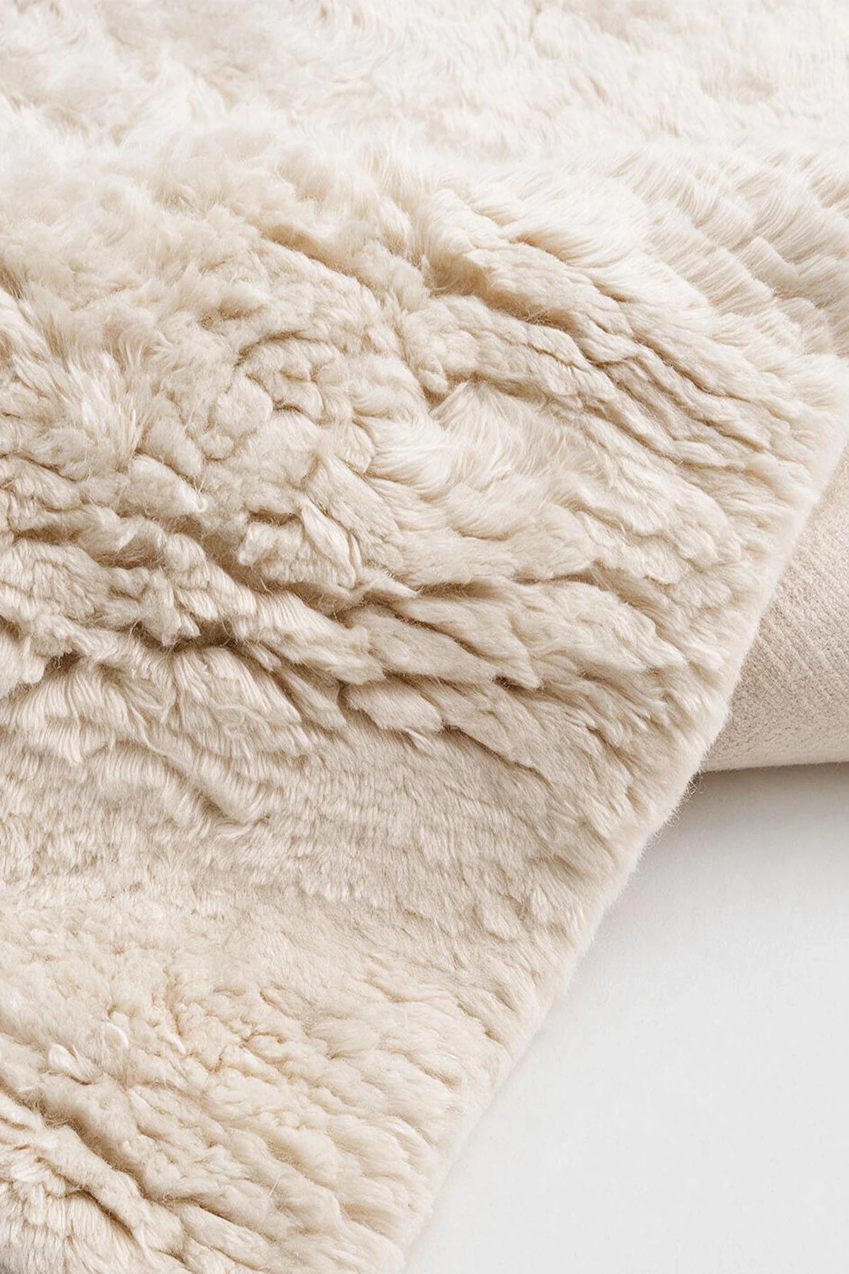 Close-up of the deep cream wool pile on a JUBI hand-knotted shag rug