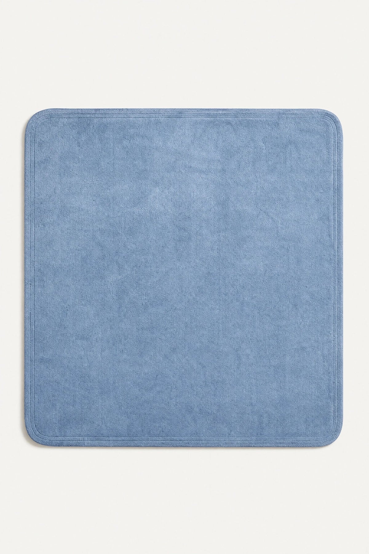 a light blue square hand-tufted wool rug with rounded corners and a double carved contour edge