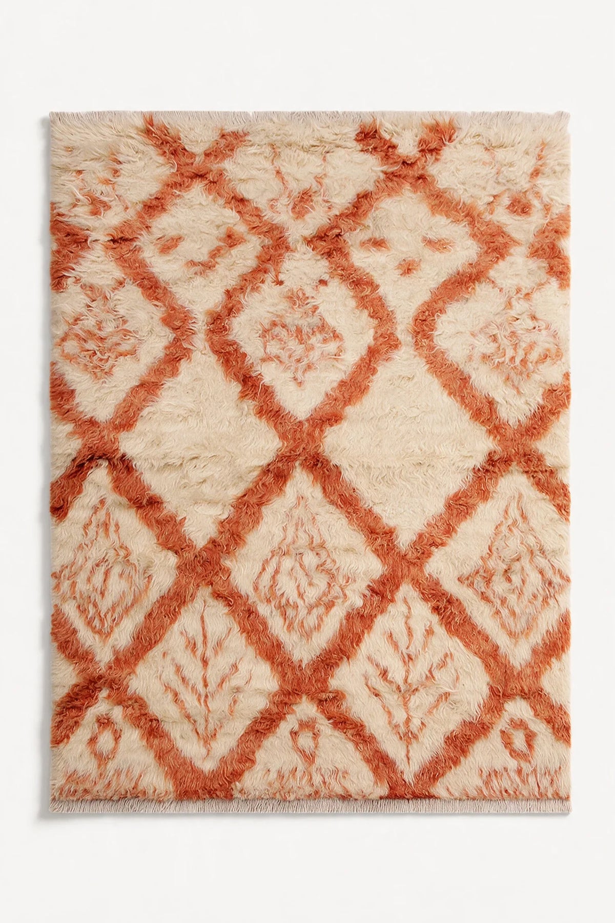 Cream and burnt orange wool shag rug in 8x10 size with diamond motif, perfect for adding texture to boho, eclectic, or modern living spaces