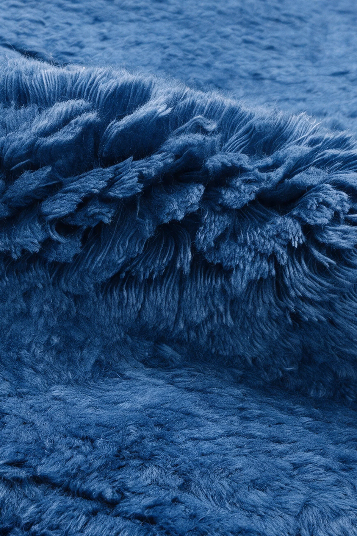 Close-up of the deep blue wool pile on a JUBI hand-knotted shag rug