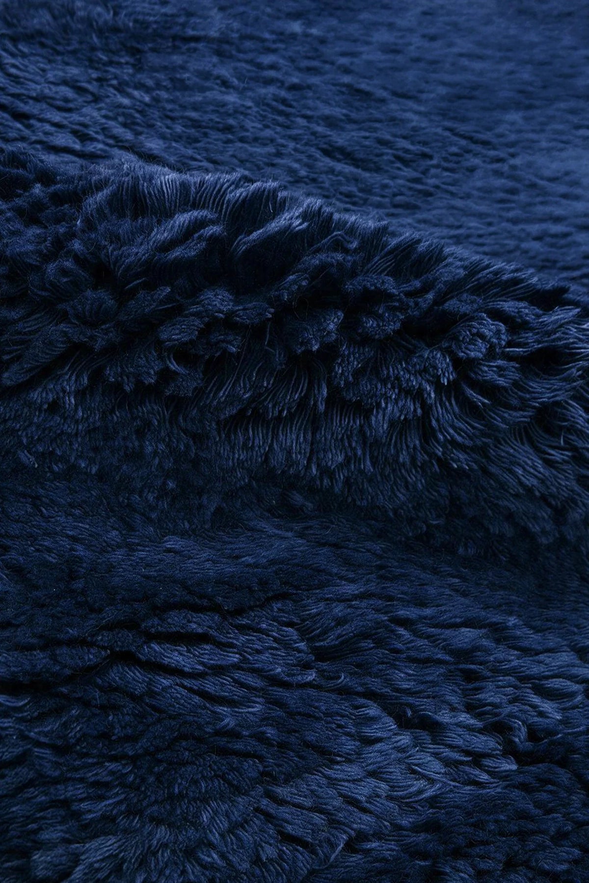 Close-up of the deep navy wool pile on a JUBI hand-knotted shag rug