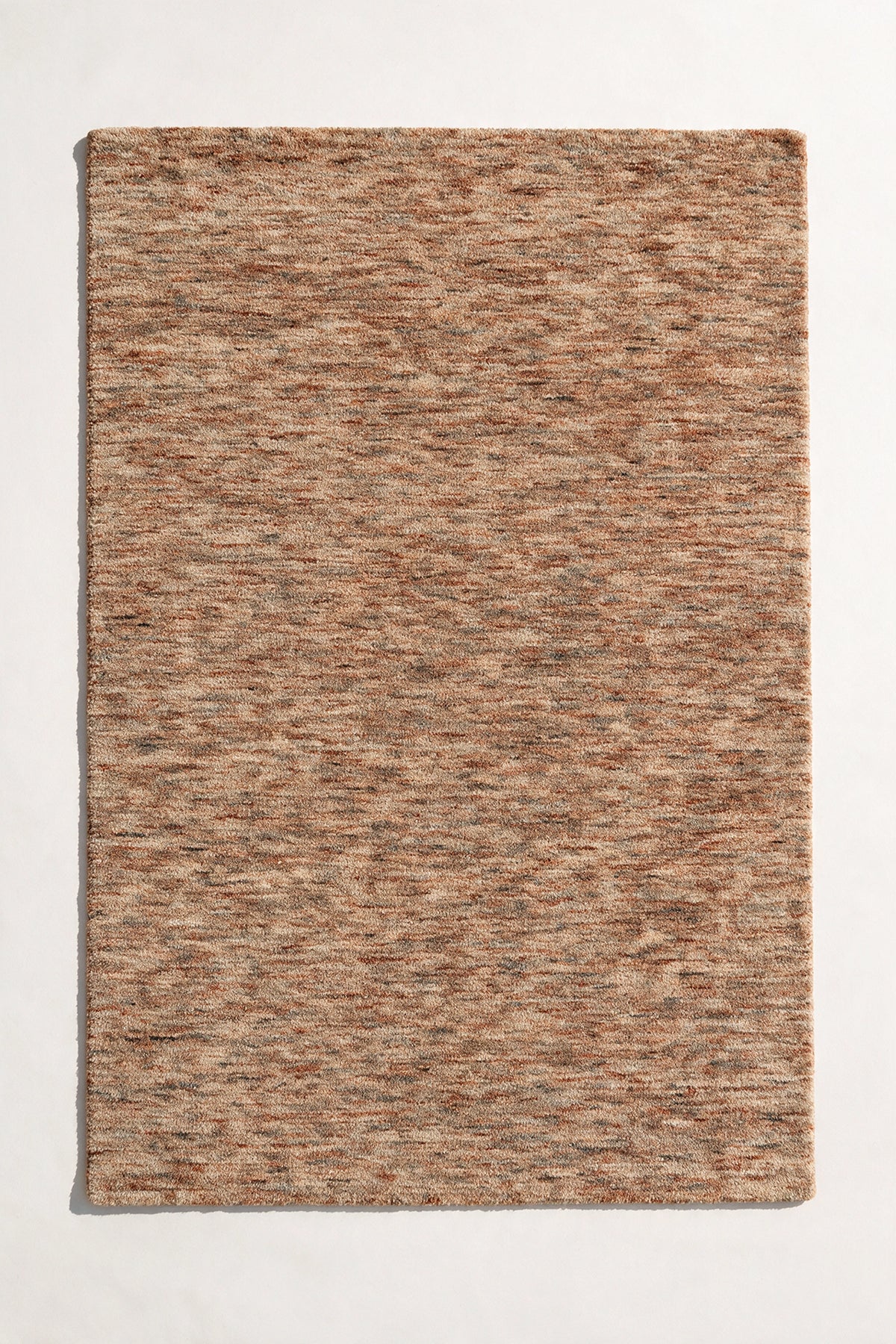 flat lay of a sienna strata hand-tufted wool rug, blended terracotta, tan and ochre yarns