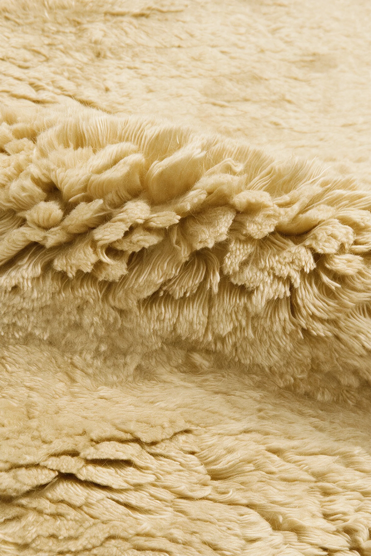 Close-up of the deep soft yellow wool pile on a JUBI hand-knotted shag rug